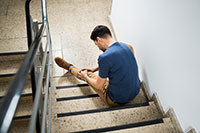 Man has fallen down stairs in a stair well.