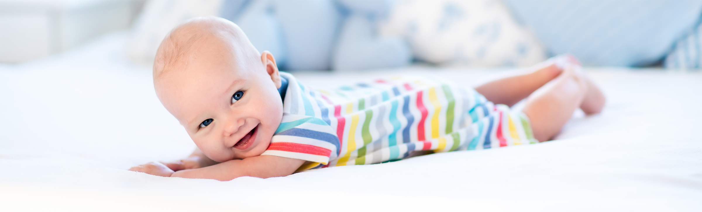 Happy baby on white blanket.