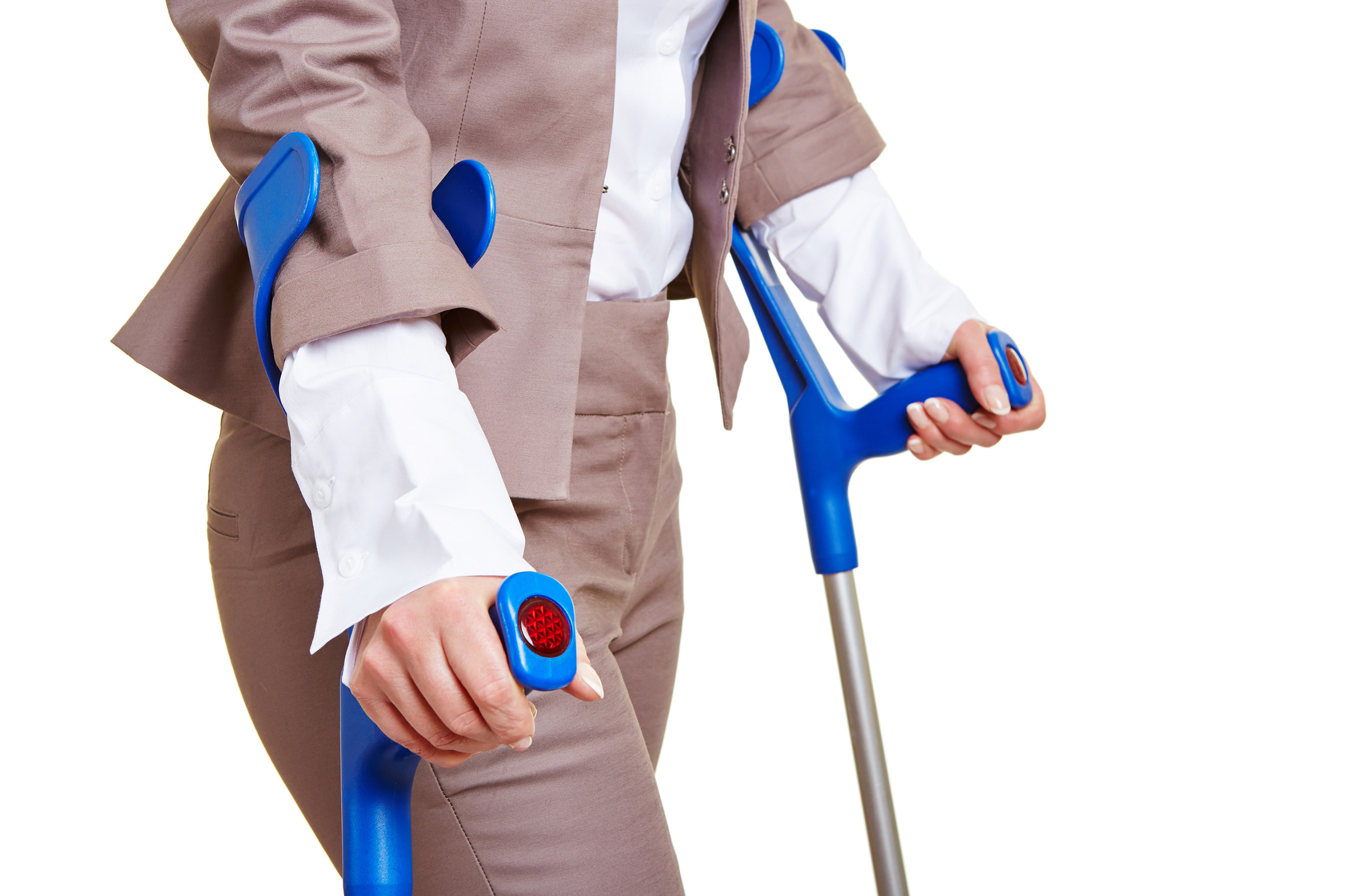 Show thumbnail preview A person wearing a beige suit and white shirt uses two blue forearm crutches for support, shown from the shoulders down against a white background.
