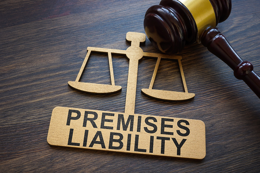 Show thumbnail preview A wooden block with the words Premises Liability sits below a scale of justice symbol, next to a judge’s gavel, all on a wooden surface.