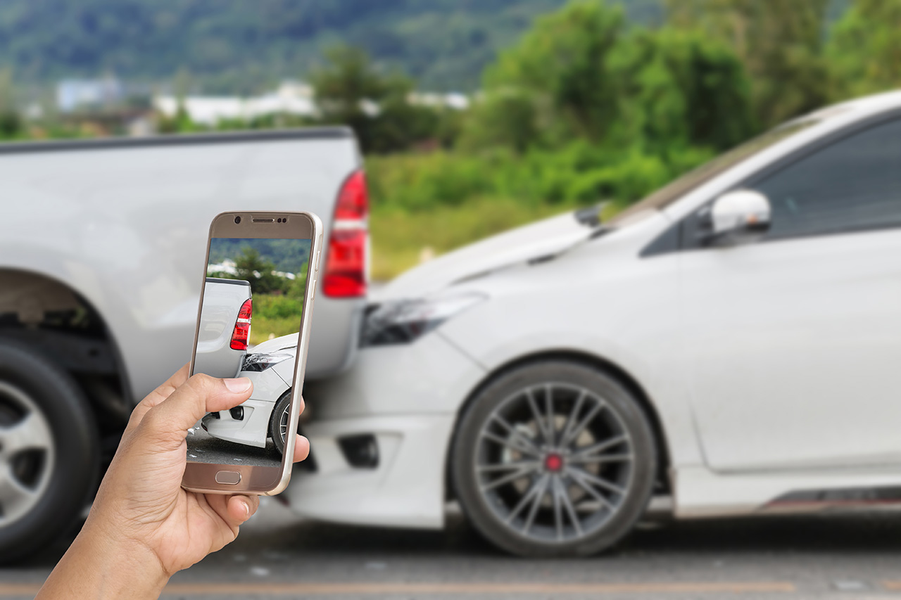 woman holding cellphone taking picture of rear end collision car accident