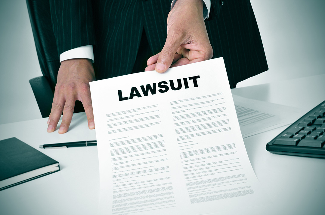 a lawyer in his office showing a document with the text lawsuit written on it