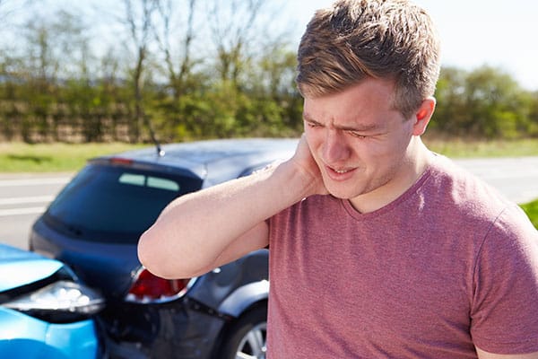 photo of auto accident victum holding neck from whiplash