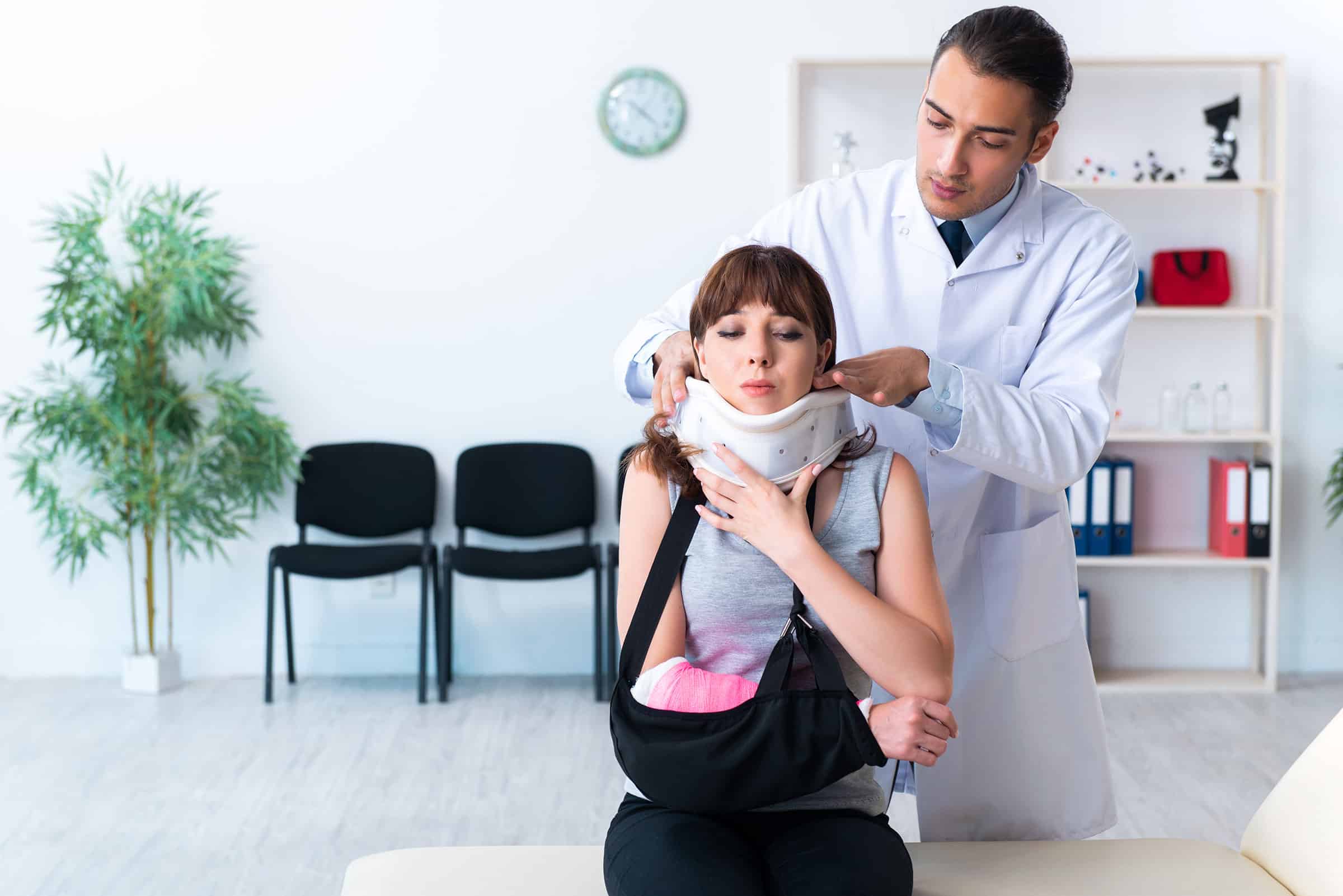 young woman accident victim being teated by doctoro in white lab coat