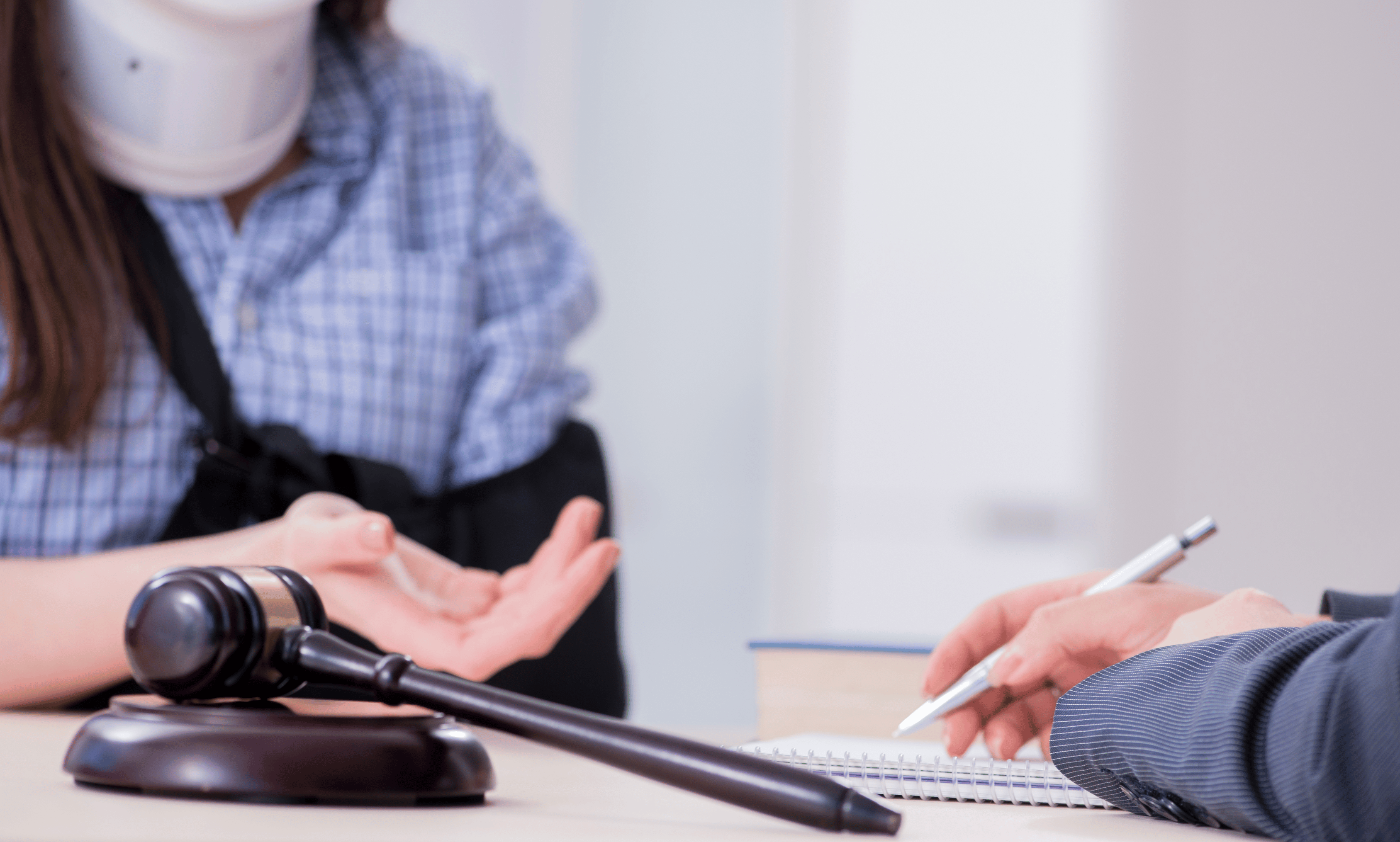 woman in wheel chair with sling on left arm talking with an attorney