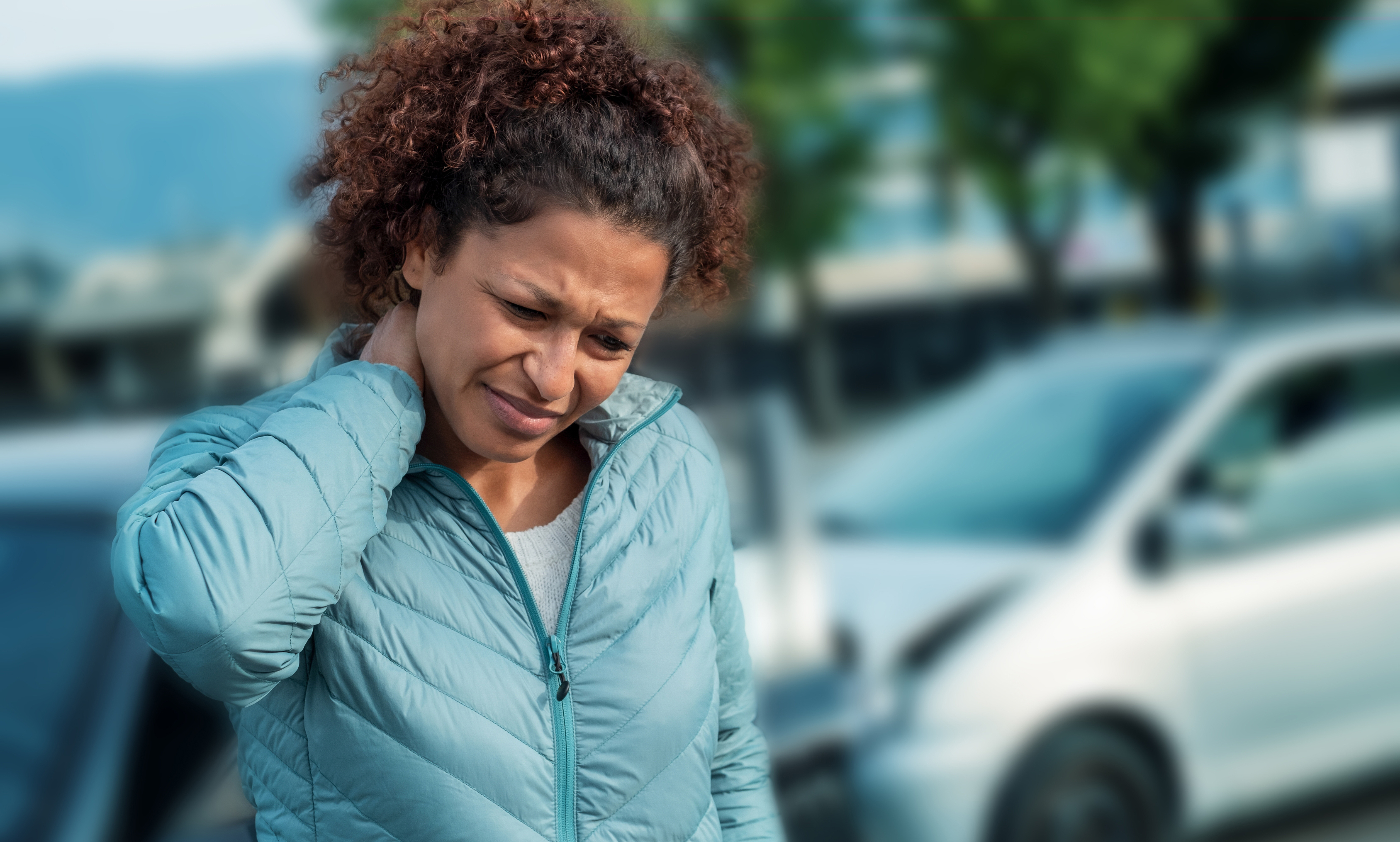 Car crash back pain - girl holding neck