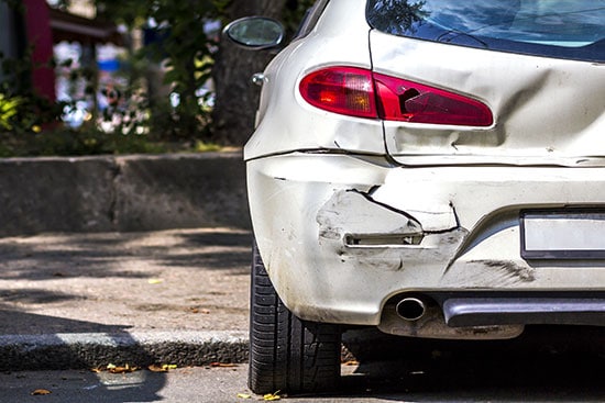 damaged white car by hit and run