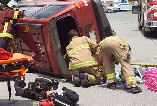 emergency team helping victims of overturned car crash