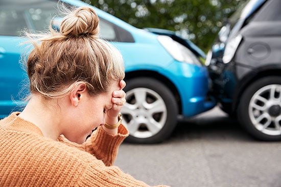 female motorist with head and hand after car accident with another car
