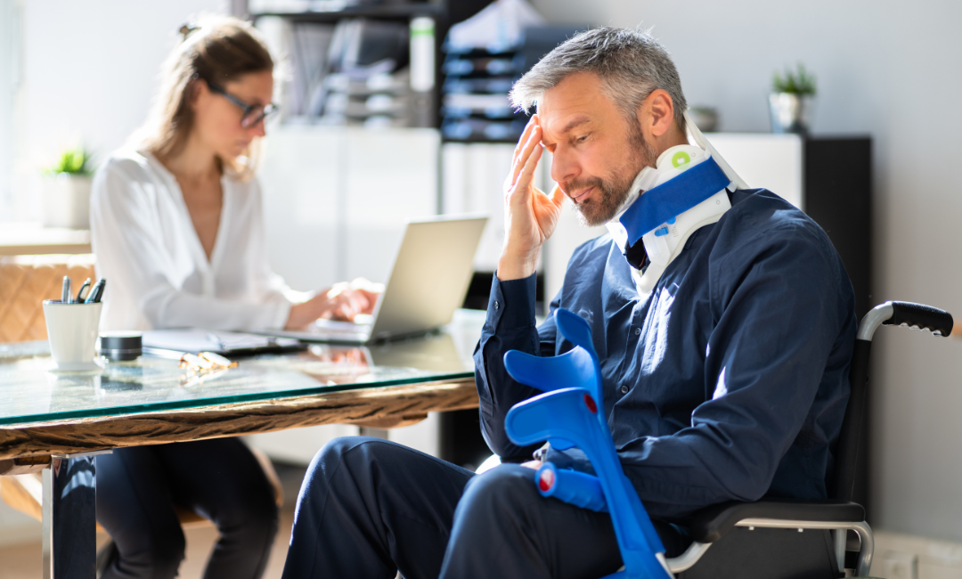 man in wheel chair with neck brace talking to lawyer