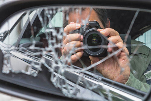 photographer taking picture of car damages after car accident