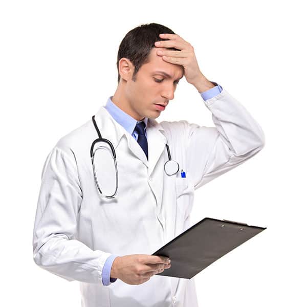 medical doctor holding head realizing he made a mistake