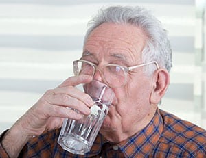 elderly man drinking water