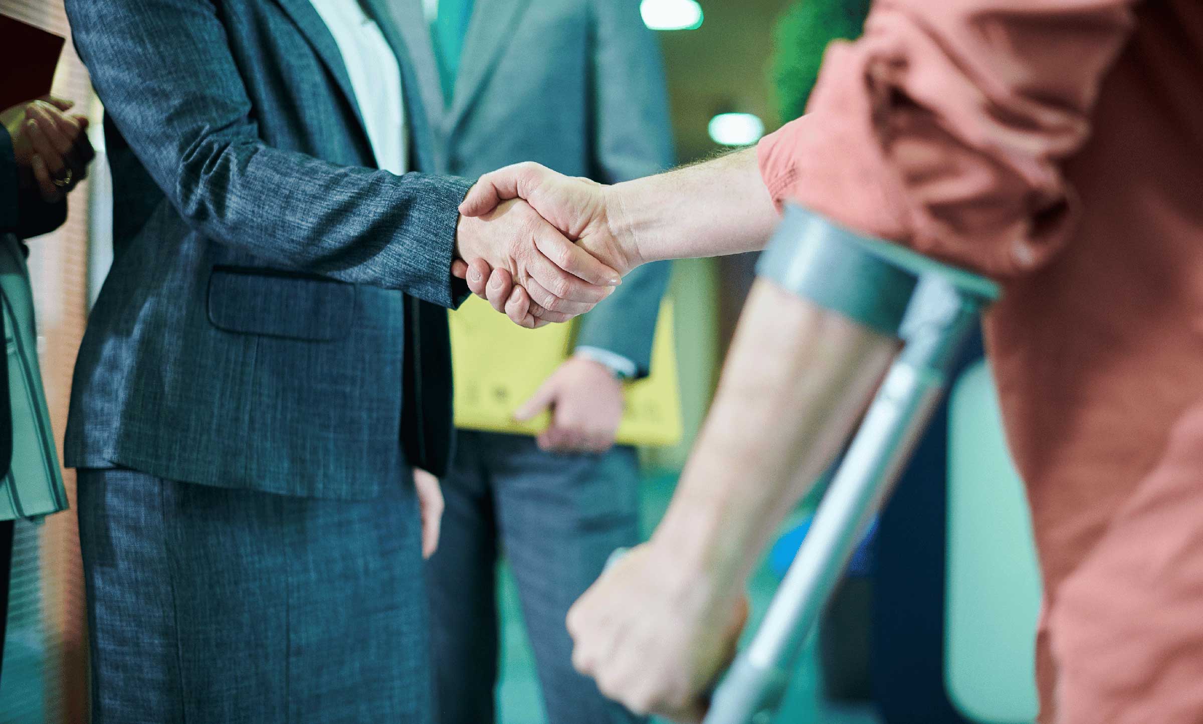 lawyer shaking hand of injured person on crutches