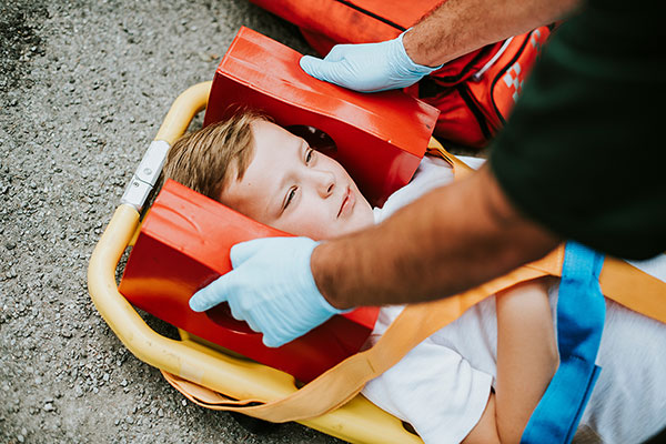 young injured boy lying on an ambulance streatcher
