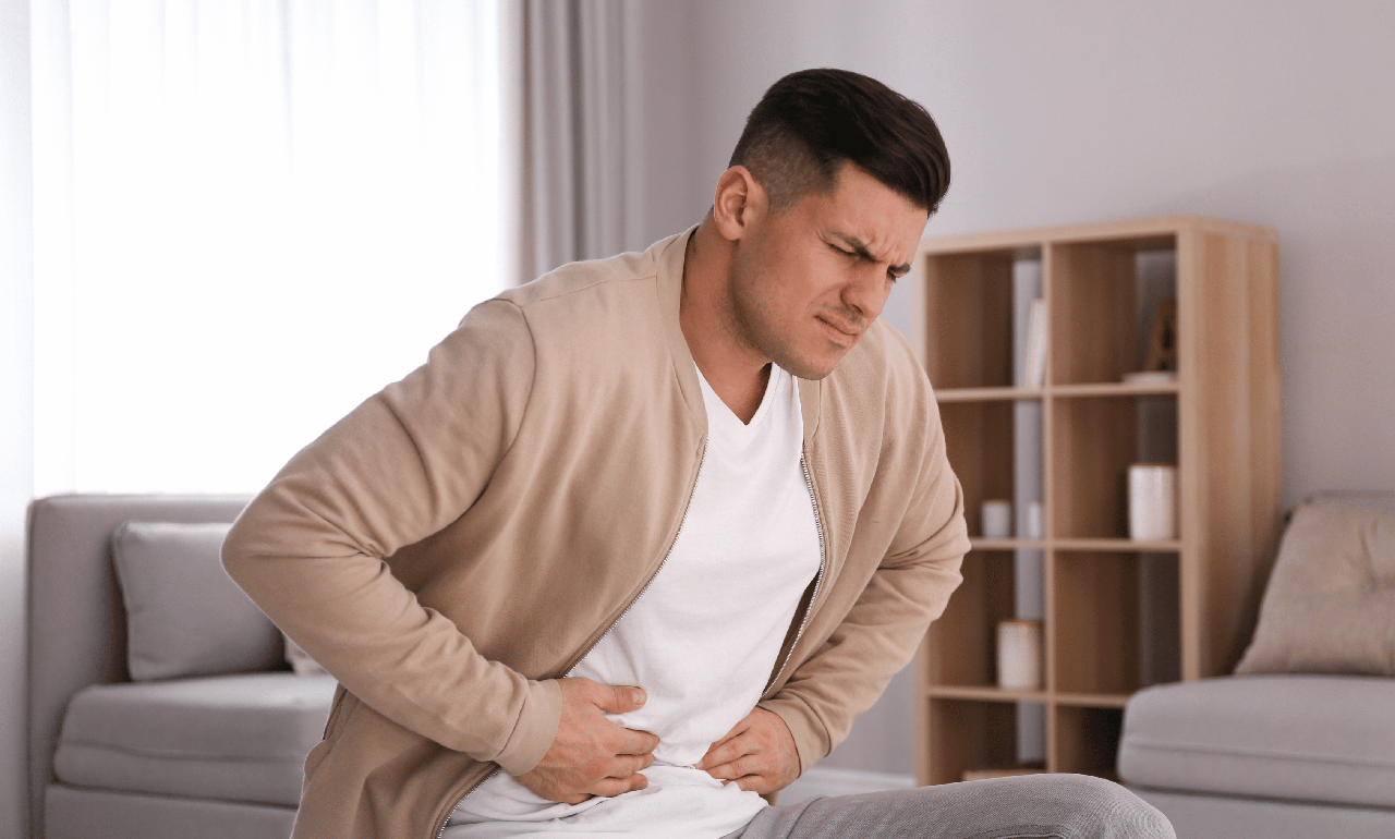 man holding stomach because of food poisoning