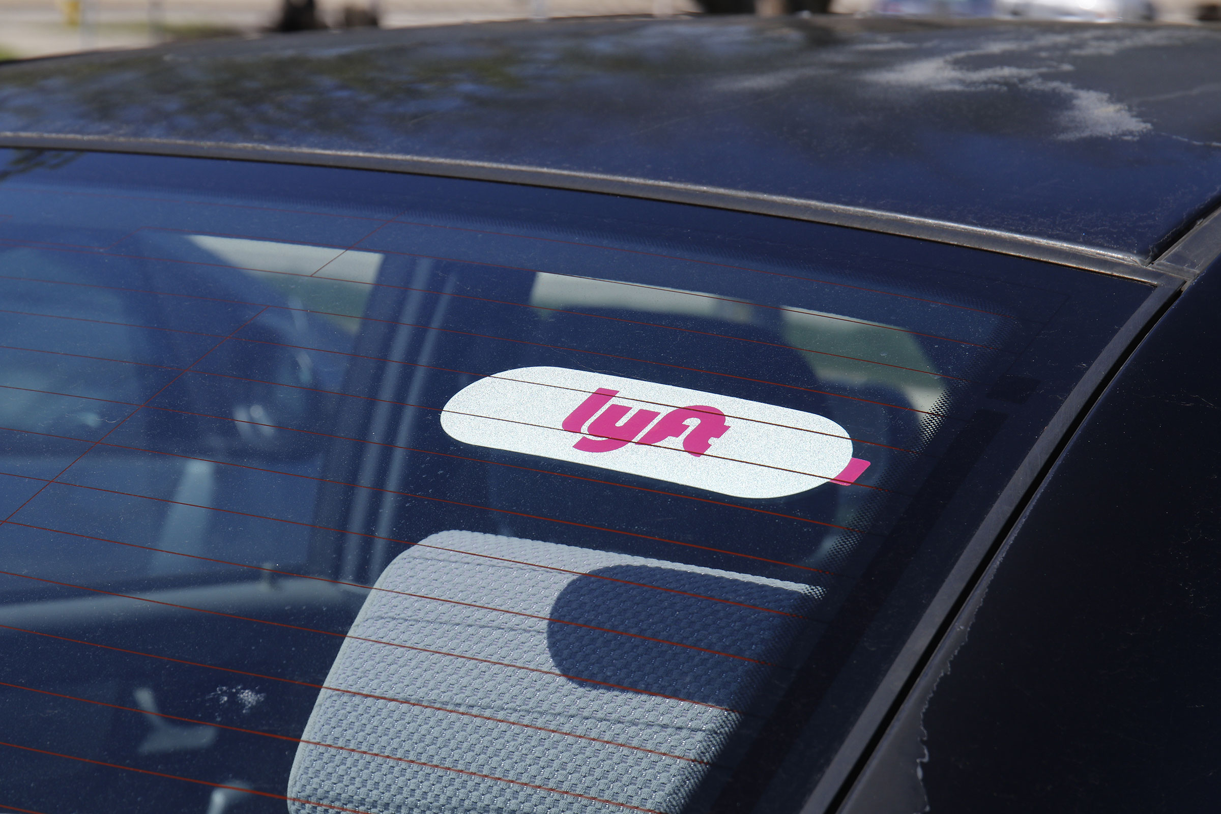 lyft sign on windshield of ride share car