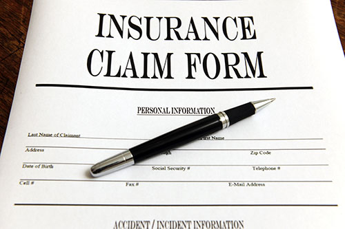 Graphic of an insurance claim form for auto accidents with a pen laying on top of it
