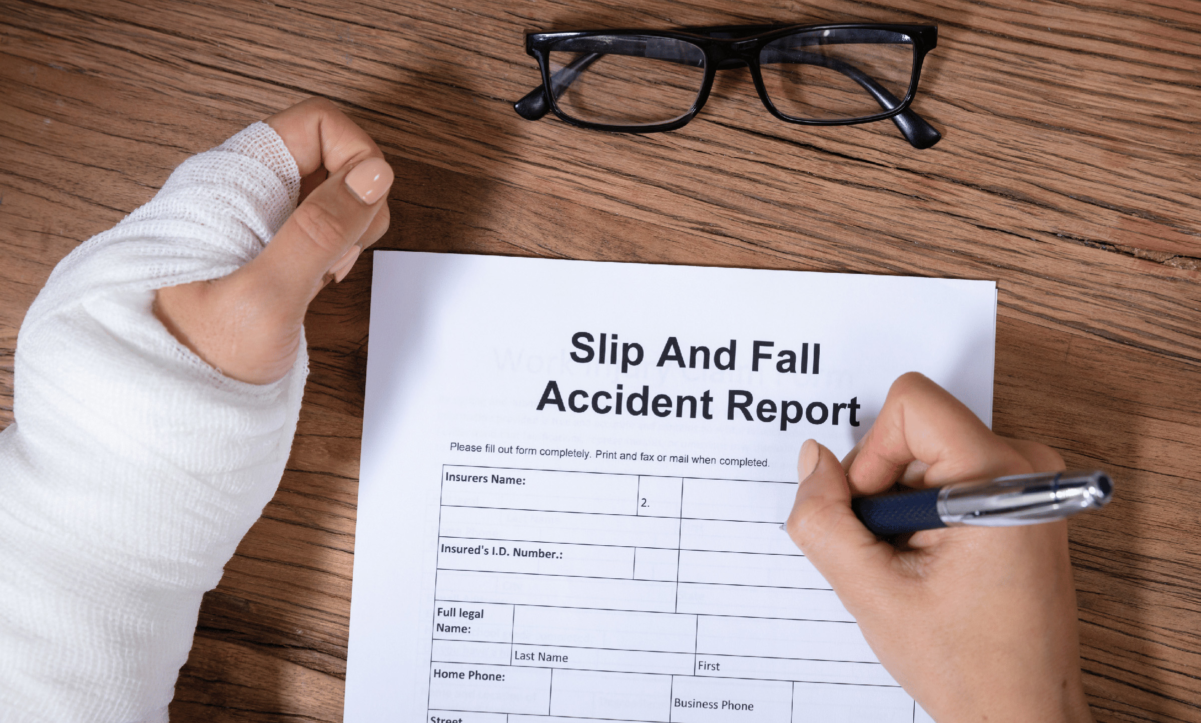 slip and fall accident report being filled out by person with broken wrist