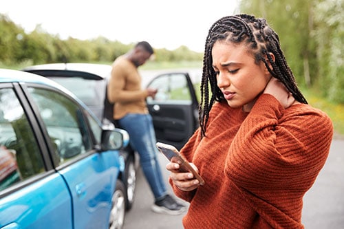 female motorist involved in car accident calling assistance