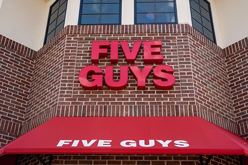 five guys sign on brick building