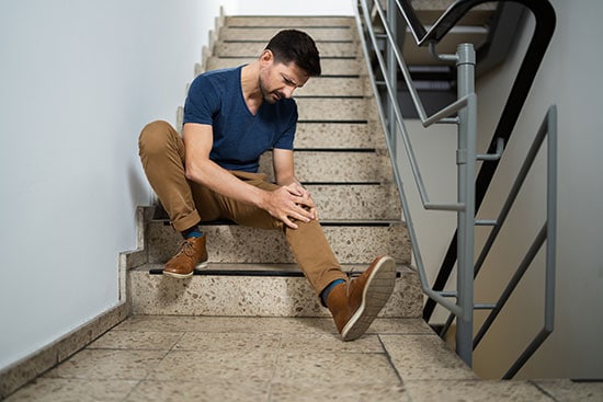 man sitting on staircase after slipping and falling in Tamarac Florida