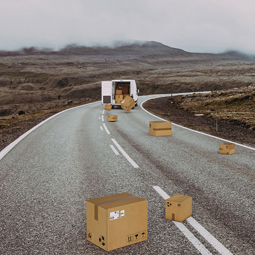 improperly loaded truck loosing cargo onto highway